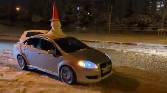 Otomobilinin tavanına yaptığı kardan adam ile şehir turu attı