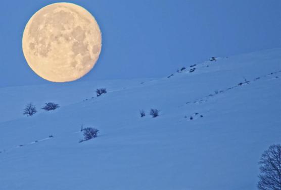 Karlı dağlar ile dolunay aynı karede güzel görüntüler oluşturdu