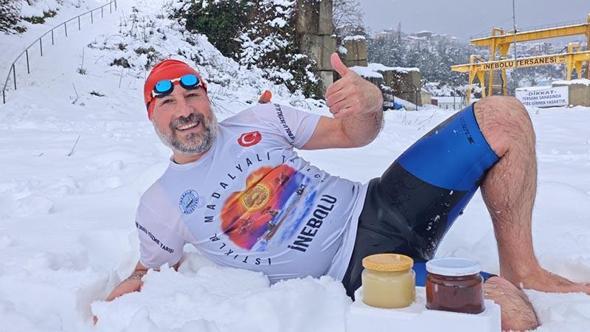 Kar altında denize girip yüzdü