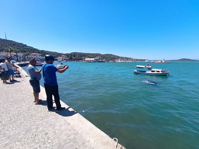 Denize uçan otomobilinin üzerinde oturup yardım bekledi