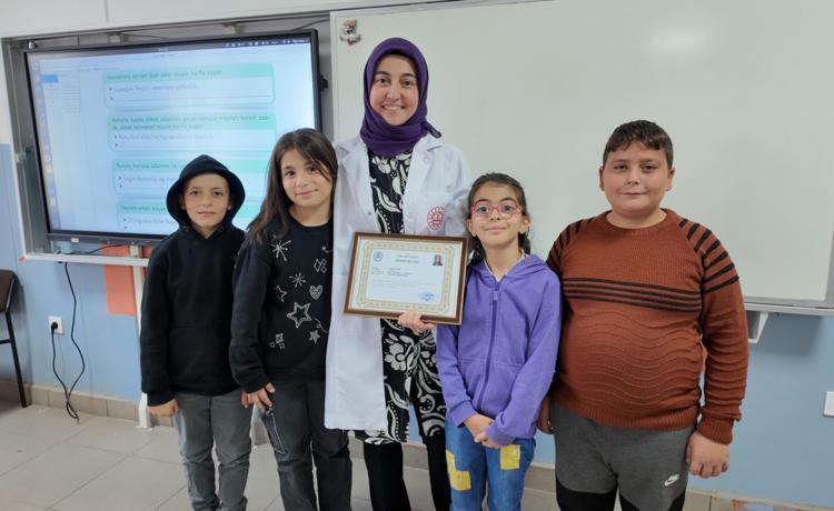 SEVDİĞİ ÖĞRETMENİNE BELGESİNİ VERDİ