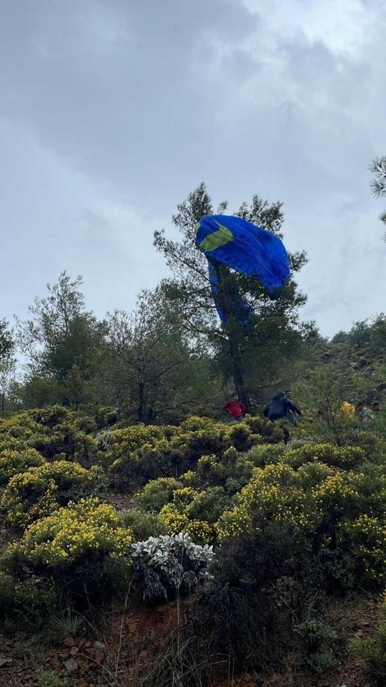 Ölüdenizde fırtına ve yağmur paraşütçüleri zorladı; 1i ağaçta asılı kaldı