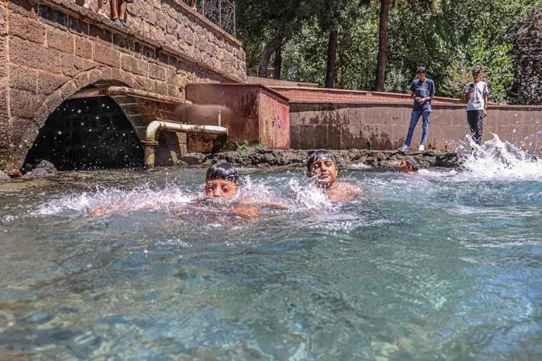 Sıcaktan bunalınca kolundaki alçıya rağmen süs havuzuna girdi