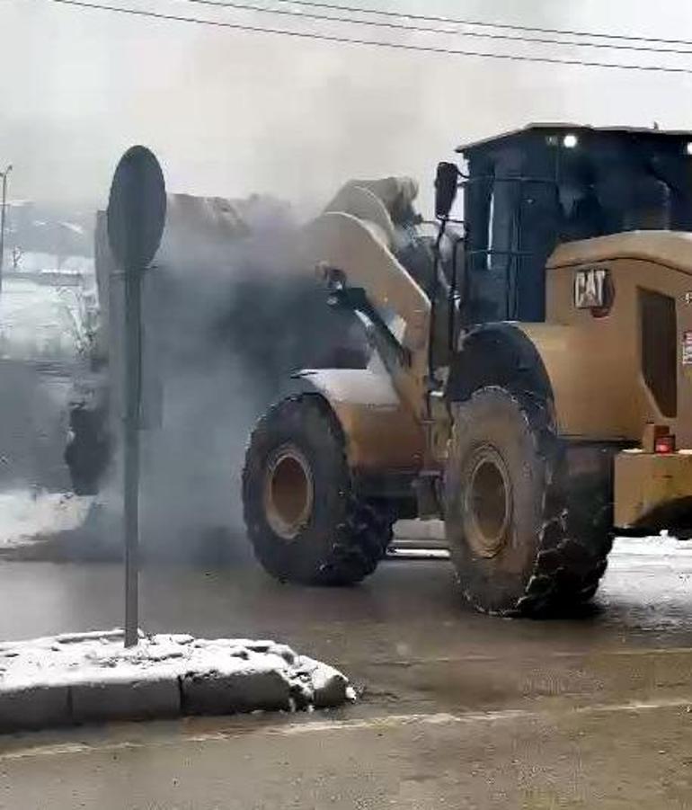 Otomobildeki yangını, iş makinesiyle toprak dökerek söndürdü