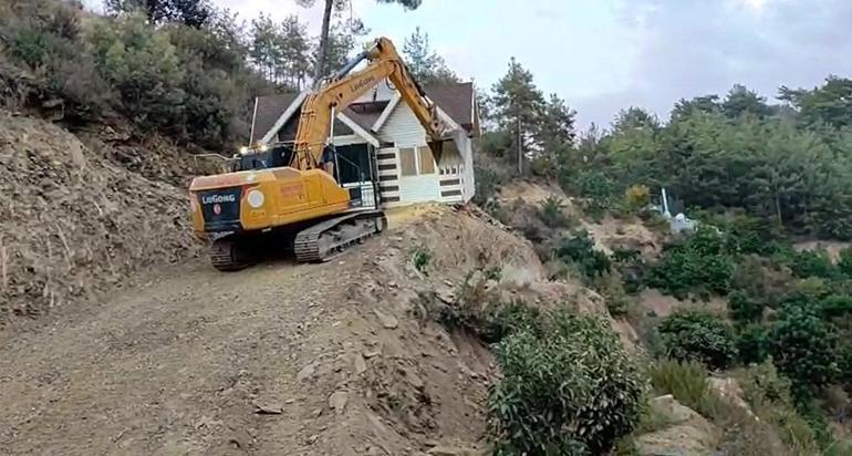 Yıkım kararı verilen konteyner evini iş makinesiyle karadan rayla yürütüp taşıdı