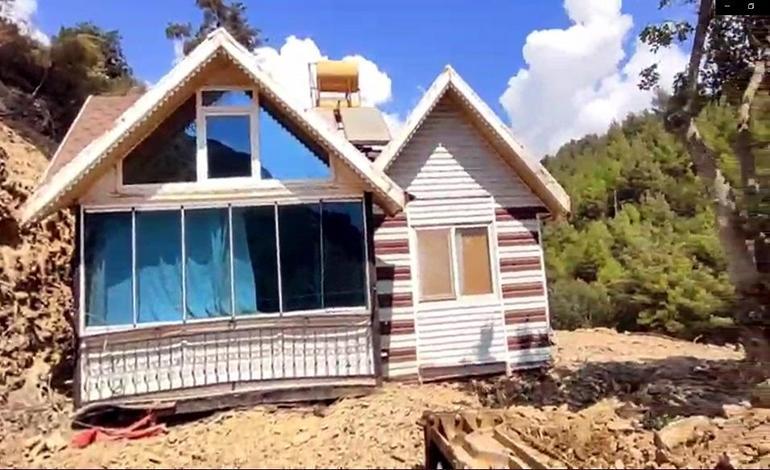 Yıkım kararı verilen konteyner evini iş makinesiyle karadan rayla yürütüp taşıdı