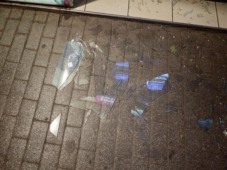 İş yerinin camını tekmeyle kıran şüpheliyi esnaf yakaladı; olay anı kamerada
