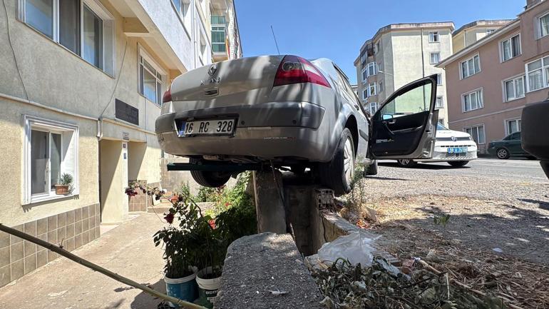 El freni çekilmeyen otomobil, hareket edip istinat duvarında asılı kaldı